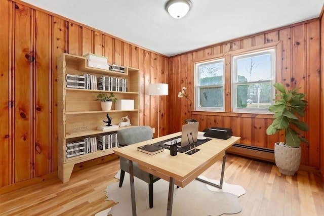 office area featuring wooden walls, a baseboard radiator, and light wood-style floors