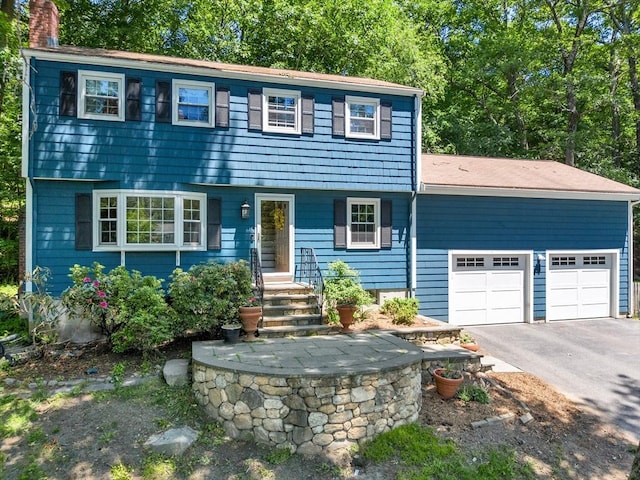 16 Vanderbelt Rd, Acton, MA 01720 - colonial inspired home with a chimney, a garage, and asphalt driveway