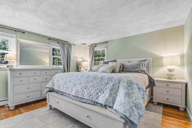 16 Vanderbelt Rd, Acton, MA 01720 - bedroom featuring wood finished floors and a textured ceiling