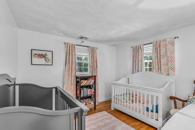 16 Vanderbelt Rd, Acton, MA 01720 - bedroom with multiple windows, wood finished floors, baseboards, and a crib
