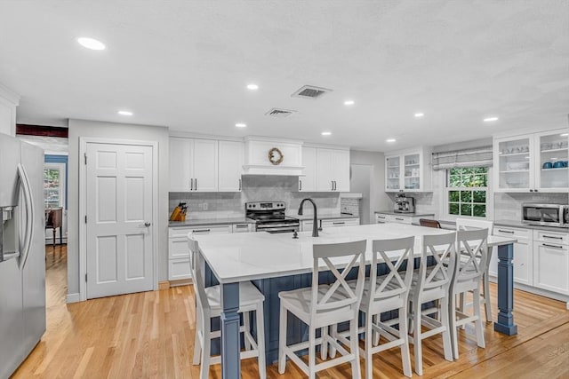16 Vanderbelt Rd, Acton, MA 01720 - kitchen featuring stainless steel appliances, a breakfast bar, an island with sink, light wood finished floors, and recessed lighting