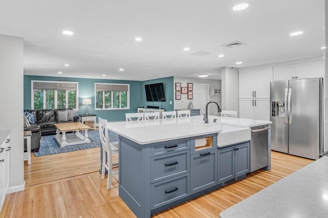 16 Vanderbelt Rd, Acton, MA 01720 - kitchen with stainless steel appliances, white cabinetry, a breakfast bar area, a sink, and recessed lighting