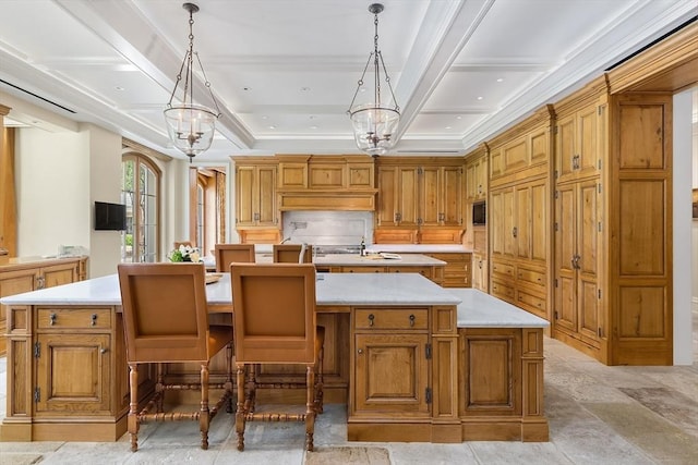 180 Ash St, Weston, MA 02493 - kitchen featuring a large island with sink, light countertops, decorative light fixtures, brown cabinetry, and ornamental molding