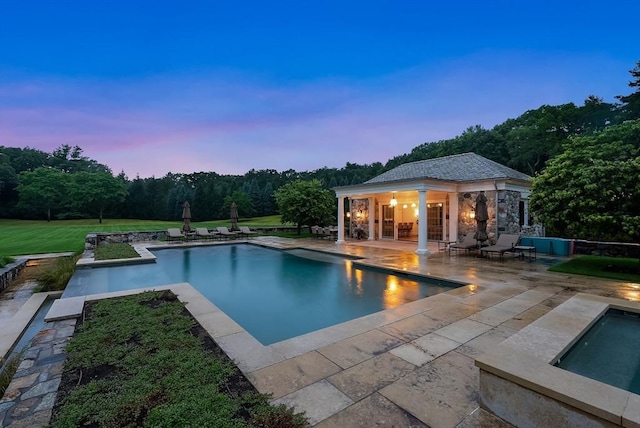 180 Ash St, Weston, MA 02493 - pool at dusk featuring a storage structure, an outdoor structure, a patio, and an outdoor pool