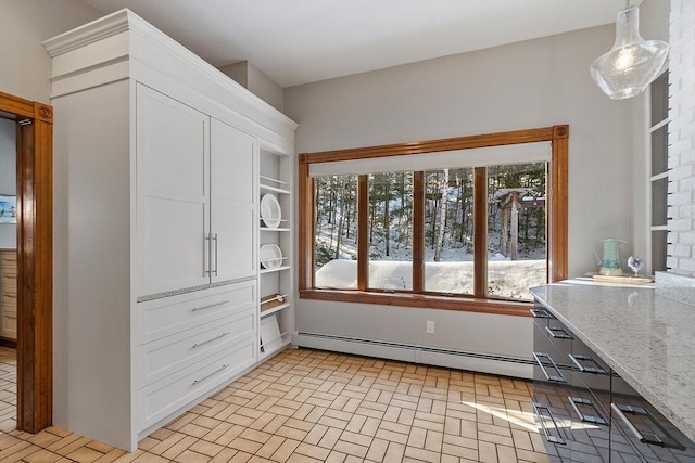 interior space featuring brick floor, a baseboard radiator, white cabinets, light stone countertops, and open shelves