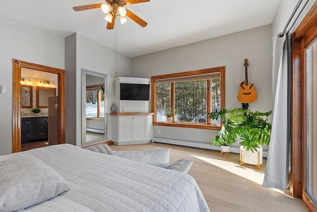 bedroom featuring a baseboard heating unit, ceiling fan, ensuite bath, and wood finished floors