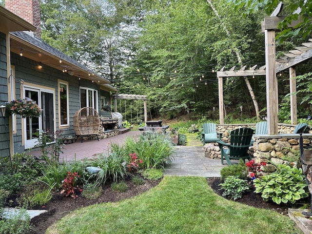 view of yard with a patio area, a wooden deck, and a pergola