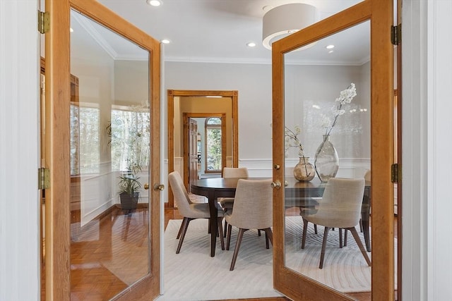 dining room with recessed lighting, wainscoting, and crown molding