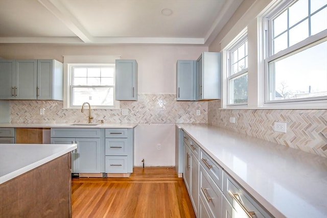 kitchen featuring decorative backsplash, sink, and light hardwood / wood-style flooring