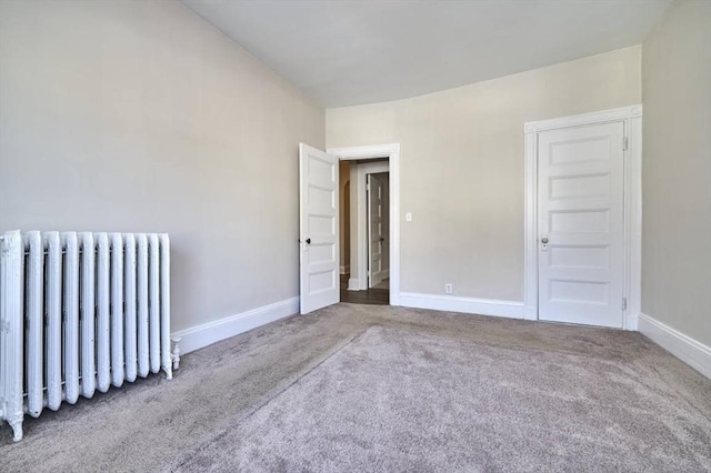 spare room with carpet flooring and radiator