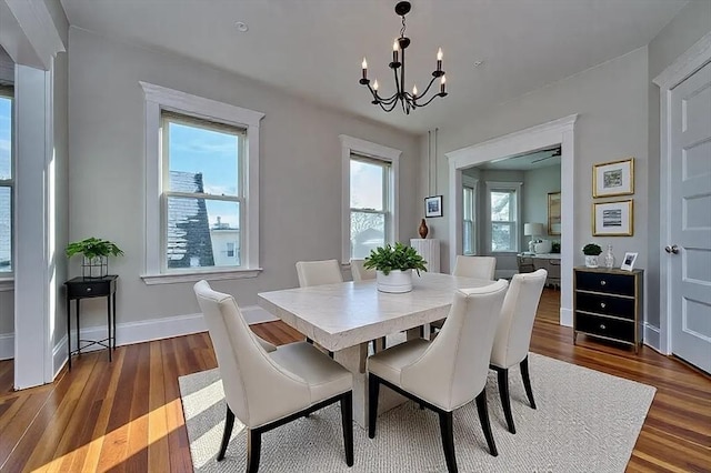 dining space featuring plenty of natural light, dark wood-type flooring, and a chandelier