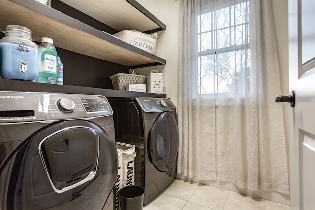 laundry area with light tile patterned floors and washer and clothes dryer