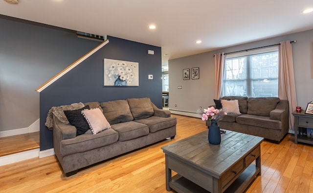 living room with light hardwood / wood-style floors and a baseboard heating unit