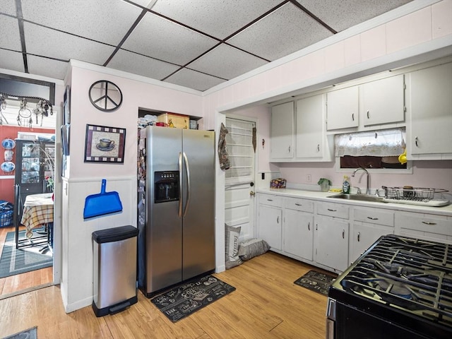 kitchen featuring stainless steel refrigerator with ice dispenser, sink, range, and light hardwood / wood-style flooring