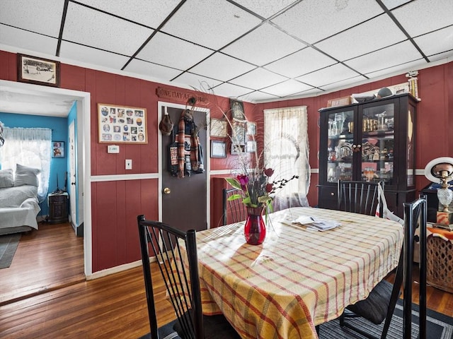 dining space with a paneled ceiling and hardwood / wood-style flooring