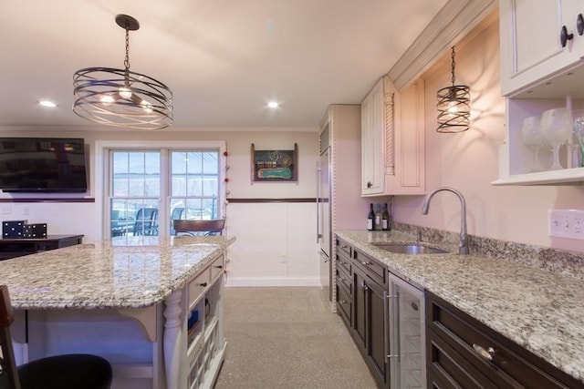 kitchen featuring white cabinetry, light stone countertops, dark brown cabinets, and sink