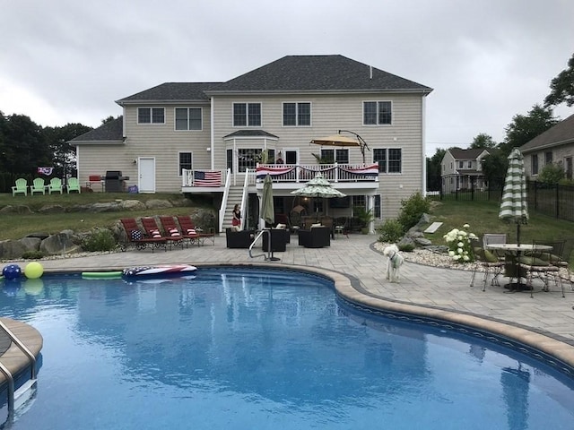 view of pool with grilling area, a patio, and a deck