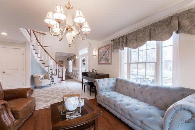 living room featuring crown molding, wood-type flooring, and an inviting chandelier