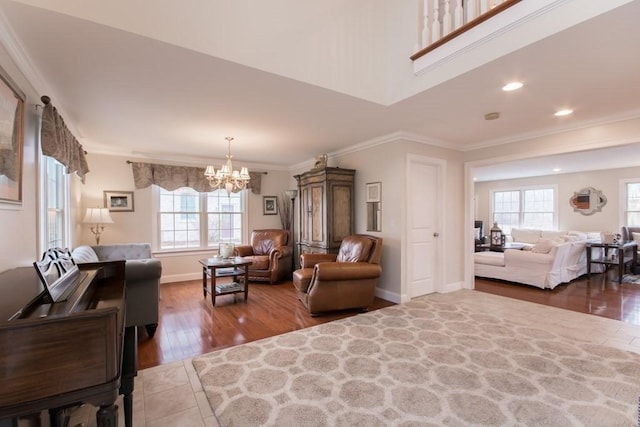 living room with hardwood / wood-style floors, crown molding, a chandelier, and a healthy amount of sunlight