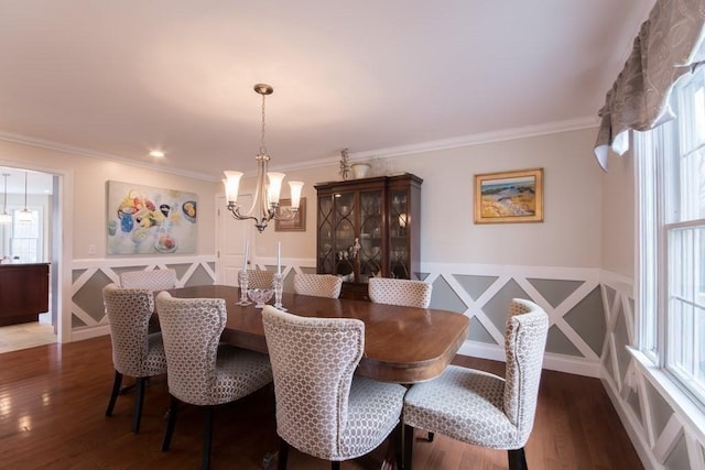 dining space with ornamental molding, a chandelier, and dark hardwood / wood-style flooring