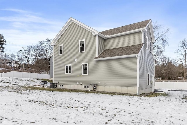 snow covered rear of property with cooling unit