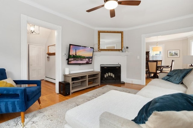 518 Washington St, Winchester, MA 01890 - living room with a baseboard radiator, a ceiling fan, crown molding, wood finished floors, and a brick fireplace