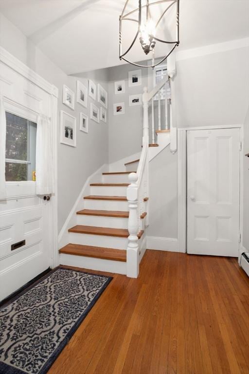 518 Washington St, Winchester, MA 01890 - stairway with wood finished floors, a chandelier, and baseboards