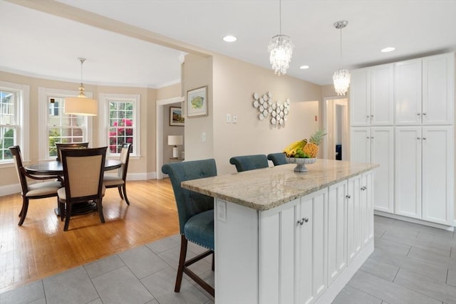 518 Washington St, Winchester, MA 01890 - kitchen with baseboards, white cabinets, a center island, a kitchen bar, and recessed lighting