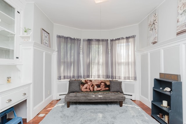 sitting room featuring ornamental molding, hardwood / wood-style floors, and a baseboard heating unit