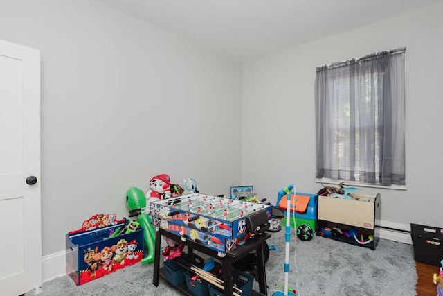 rec room with a baseboard radiator and wood-type flooring