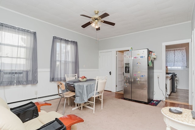 dining area featuring ceiling fan, a baseboard radiator, light hardwood / wood-style flooring, and ornamental molding