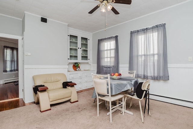 dining area featuring ceiling fan, a baseboard radiator, light hardwood / wood-style floors, and ornamental molding