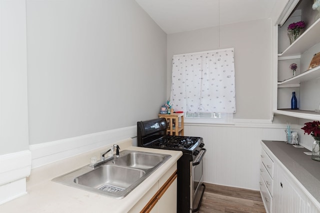 kitchen featuring white cabinetry, gas stove, hardwood / wood-style flooring, and sink