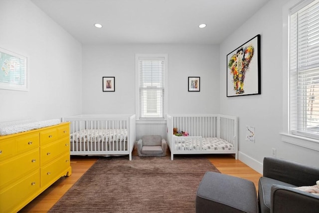 424-430 W 4th St Unit 428, Boston, MA 02127 - bedroom with wood finished floors, a crib, and recessed lighting