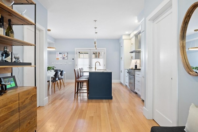 424-430 W 4th St Unit 428, Boston, MA 02127 - kitchen with high end stainless steel range oven, french doors, light wood-style floors, a breakfast bar area, and recessed lighting