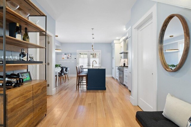 424-430 W 4th St Unit 428, Boston, MA 02127 - kitchen featuring light wood-type flooring, french doors, a breakfast bar, high end range, and open shelves