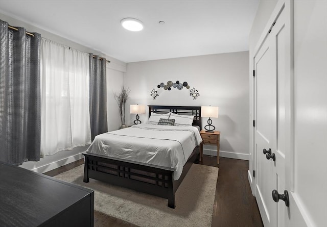 bedroom with dark hardwood / wood-style floors