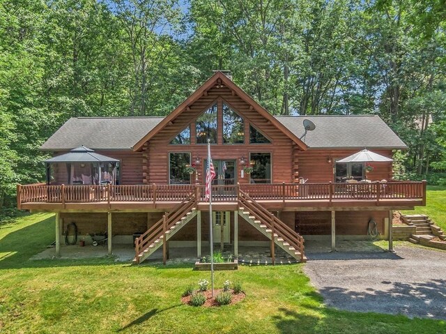 8 Turk Hollow Rd, Oxford, MA 01540 - back of house with log siding, stairway, a lawn, and a shingled roof