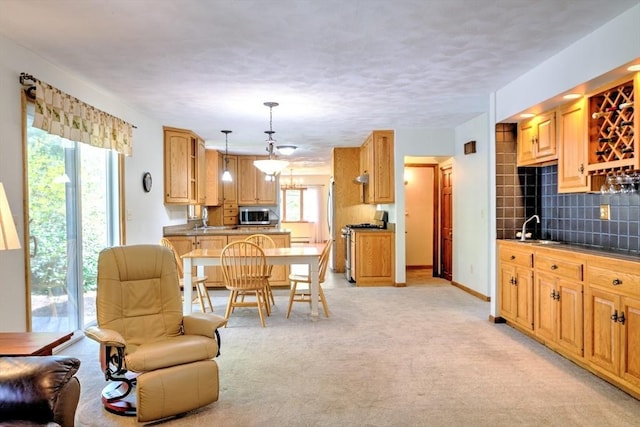 kitchen featuring a sink, light carpet, stainless steel appliances, and backsplash