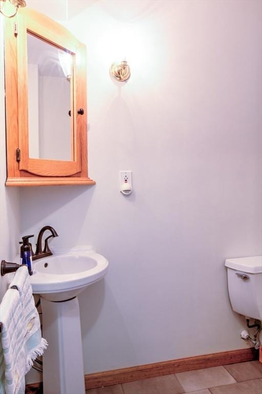 bathroom featuring toilet, baseboards, and tile patterned floors