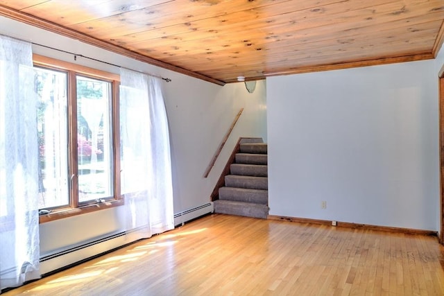 spare room with wood ceiling, light wood-type flooring, a baseboard heating unit, ornamental molding, and stairs