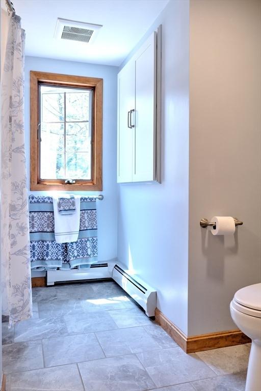 full bath with visible vents, baseboards, curtained shower, and toilet