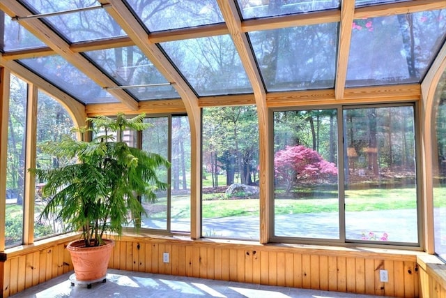 unfurnished sunroom featuring wooden walls and a wealth of natural light
