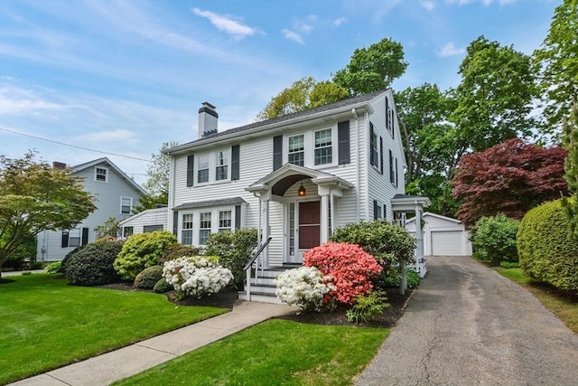 21 Stevens Rd, Needham, MA 02492 - view of front of home featuring a chimney, an outdoor structure, a front lawn, and a detached garage