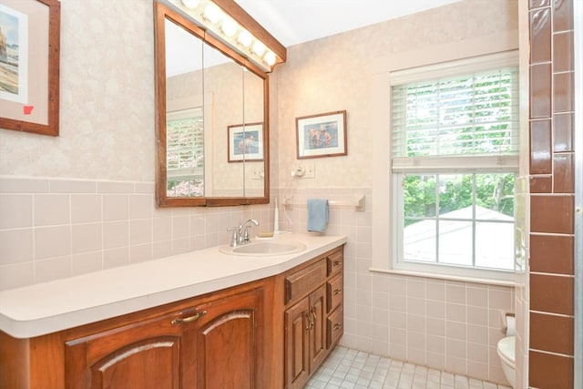 21 Stevens Rd, Needham, MA 02492 - bathroom with wallpapered walls, tile walls, vanity, toilet, and a wainscoted wall