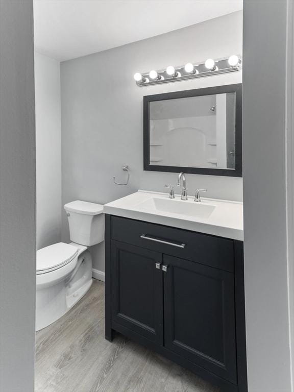 bathroom featuring vanity, hardwood / wood-style floors, and toilet