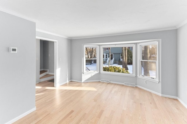 unfurnished room with ornamental molding and light wood-type flooring