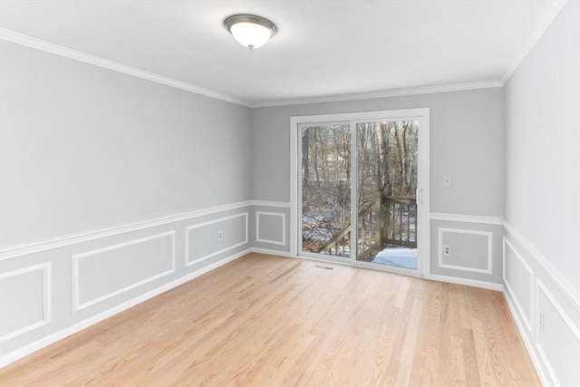 empty room featuring crown molding and light hardwood / wood-style floors