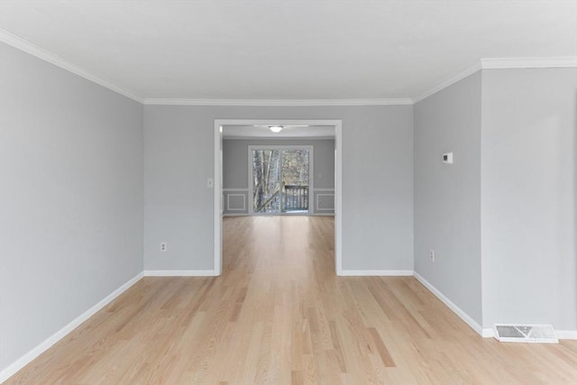 spare room featuring light hardwood / wood-style flooring and ornamental molding