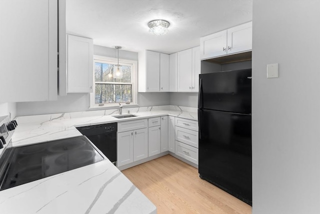 kitchen with sink, black appliances, white cabinets, decorative light fixtures, and light wood-type flooring